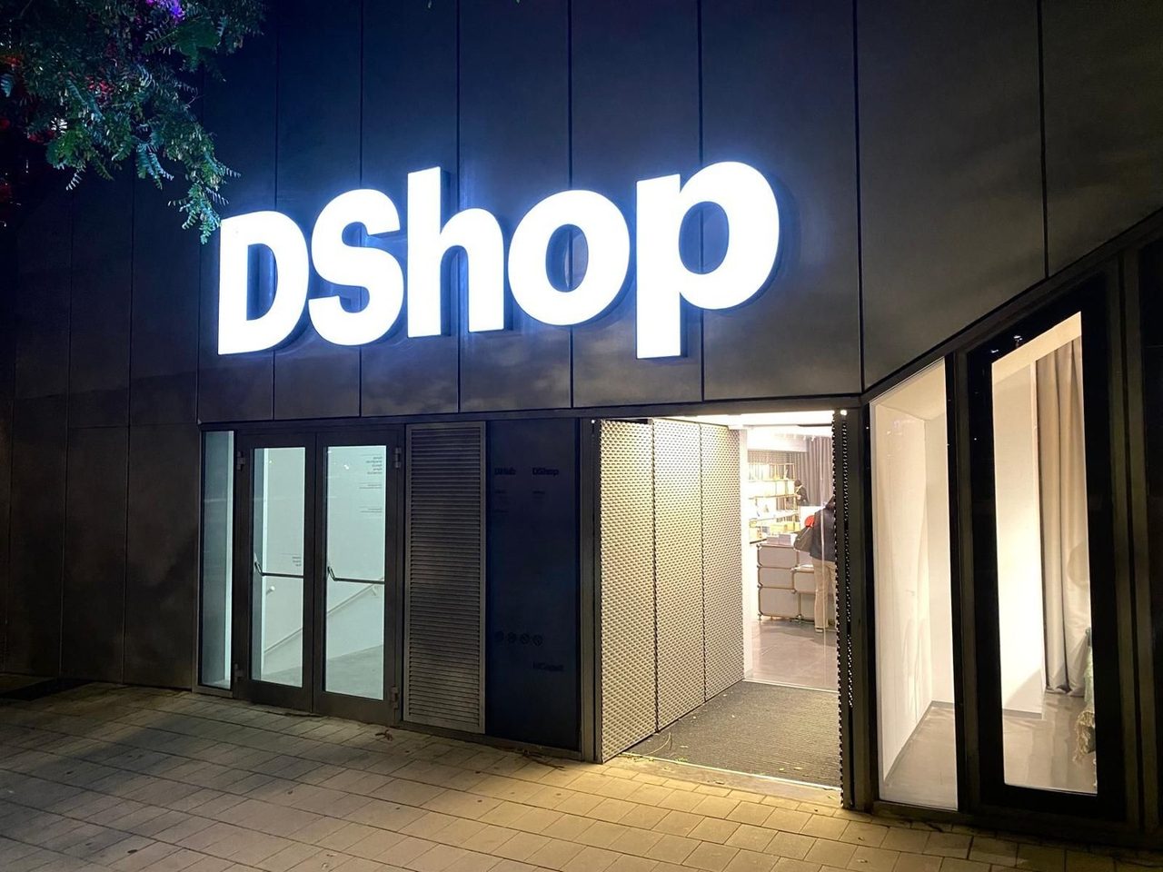 Rótulo luminoso de DShop de noche